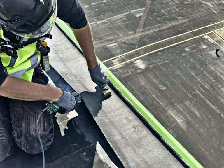 Dachdecker verschweißt die Naht einer Dachbahn an der Dachkante, Brunsbüttel