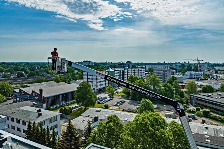 Unser Kran mit Arbeitskorb und der Aufschrift Kranverleih über den Dächern von Hamburg