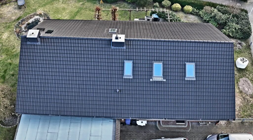Neu eingedecktes Steildach mit dunklen Dachziegeln und Dachfenstern, von oben, Uetersen